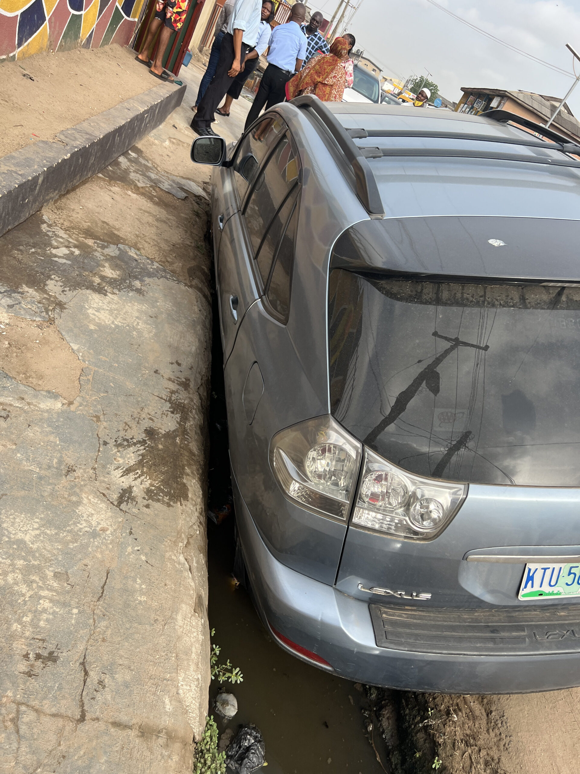 Lagos will drive you mad" Man concludes after his wife parked her car to drop the kids at school only to find it in the gutter when she returned