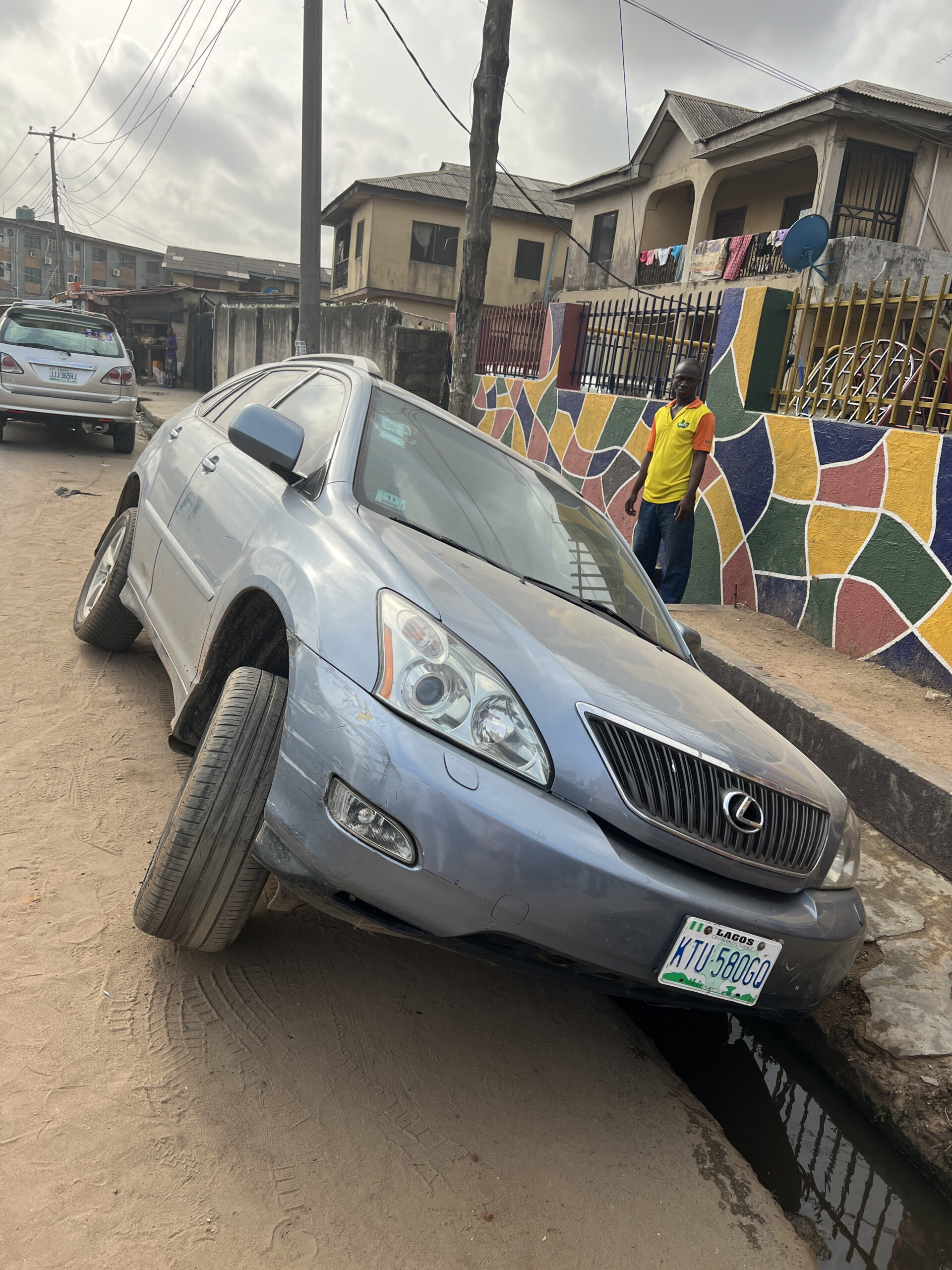 Lagos will drive you mad" Man concludes after his wife parked her car to drop the kids at school only to find it in the gutter when she returned